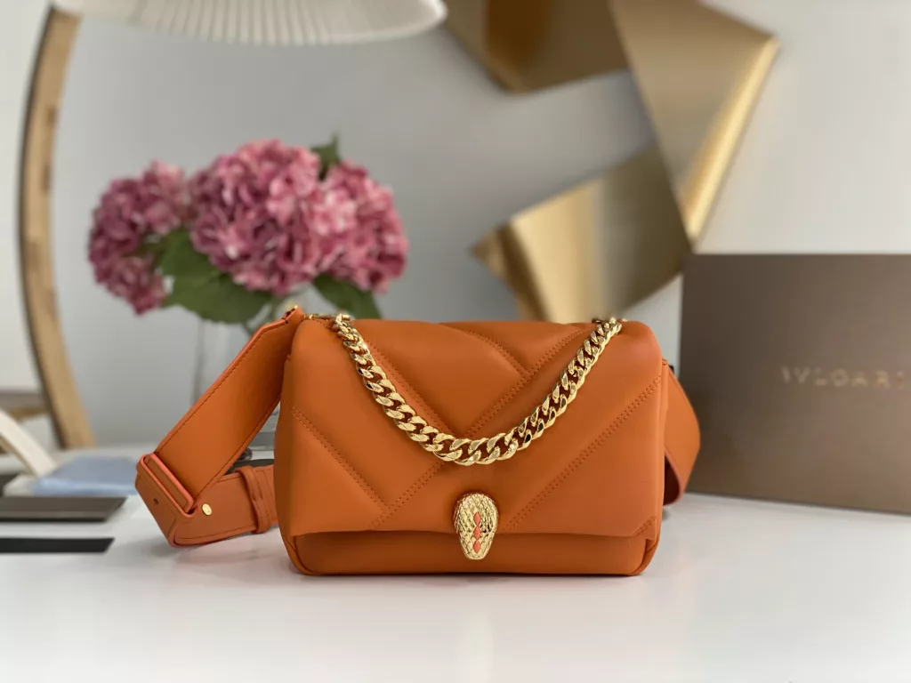 Bulgari BVLGARI-Spring Summer 2022 Orange<br>The color from the summer ocean (22㎝)<br>The Serpenti Cabochon quilted bag is the highlight of BVLGARI this summer - firstly, the classic quilted pattern is enlarged in proportion, the bag looks full and geometric; and then a white lac thick chain is added to decorate, the rugged style is modern. The bag is made of orange stones and imported first layer calf leather, decorated with delicate orange onyx snake scales and gold-plated snake head clasp with mother-of-pearl snake scales in the center, embellished with red enamel eyes.<br>291089# Size: 22.5<em>15</em>10cm<br>291085# Size: 18<em>12</em>8cm