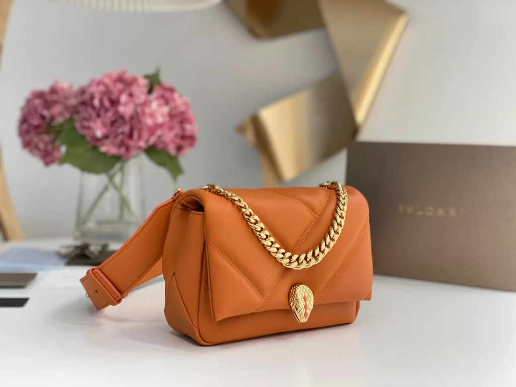 Bulgari BVLGARI-Spring Summer 2022 Orange<br>The color from the summer ocean (22㎝)<br>The Serpenti Cabochon quilted bag is the highlight of BVLGARI this summer - firstly, the classic quilted pattern is enlarged in proportion, the bag looks full and geometric; and then a white lac thick chain is added to decorate, the rugged style is modern. The bag is made of orange stones and imported first layer calf leather, decorated with delicate orange onyx snake scales and gold-plated snake head clasp with mother-of-pearl snake scales in the center, embellished with red enamel eyes.<br>291089# Size: 22.5<em>15</em>10cm<br>291085# Size: 18<em>12</em>8cm