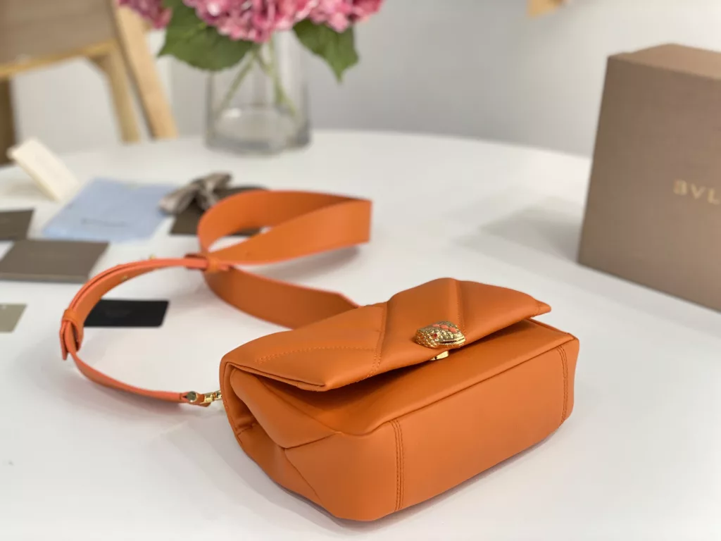 Bulgari BVLGARI-Spring Summer 2022 Orange<br>The color from the summer ocean (22㎝)<br>The Serpenti Cabochon quilted bag is the highlight of BVLGARI this summer - firstly, the classic quilted pattern is enlarged in proportion, the bag looks full and geometric; and then a white lac thick chain is added to decorate, the rugged style is modern. The bag is made of orange stones and imported first layer calf leather, decorated with delicate orange onyx snake scales and gold-plated snake head clasp with mother-of-pearl snake scales in the center, embellished with red enamel eyes.<br>291089# Size: 22.5<em>15</em>10cm<br>291085# Size: 18<em>12</em>8cm