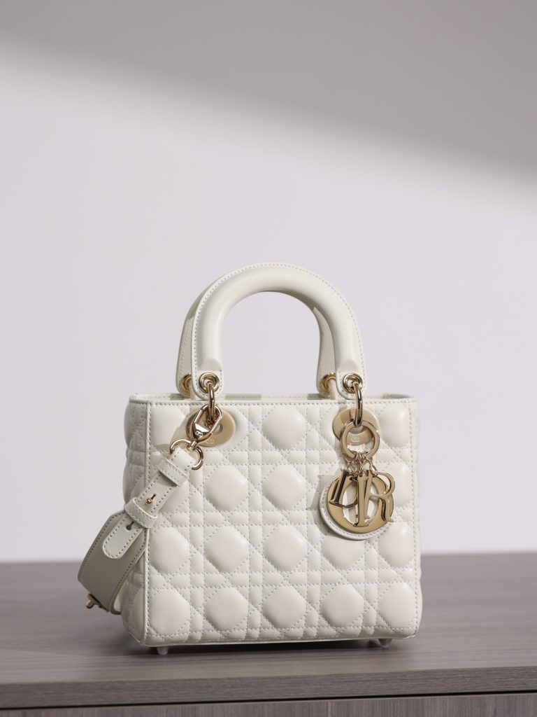 Small LADY DIOR handbag<br>White sheepskin rattan plaid<br>Four compartments Dior bag white sheepskin gold buckle<br>Exclusive channel goods debut with 7 exclusive badges<br>Size information: 20 x 17 x 8 cm<br>This Lady Dior My ABCDior clutch focuses on Dior's deep insight into elegance and beauty.<br>Crafted from white lamb leather with striking quilted details in a vine check pattern, its chic and elegant design is timeless.<br>The light gold finish metal D.I.O.R. charm is an elegant touch.<br>The small, chic design features a shoulder strap that can be adorned with a badge to show off your personality, and can be carried or slung.<br>The wide, adjustable shoulder strap includes three badges for a personalized look. A total of six badges are available for decoration.<br>Interior zippered pocket<br>Additional embroidered straps available<br>Dust bag included<br>Comes in exclusive counter packaging