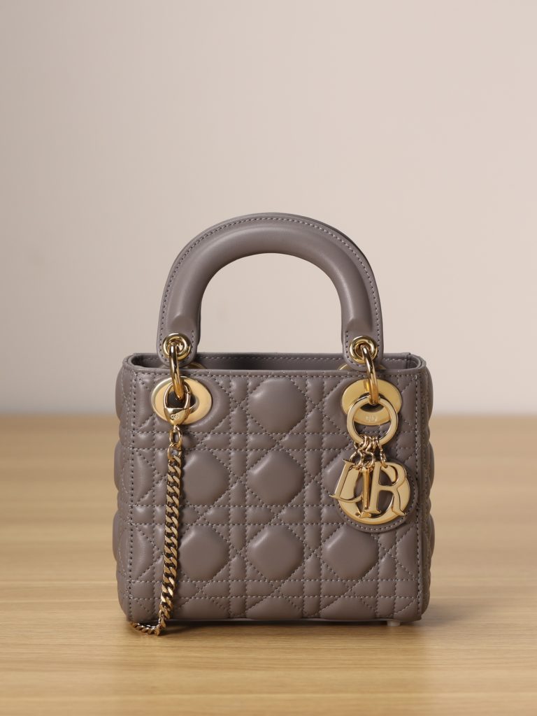 Mini LADY DIOR handbag<br>Elephant grey lamb leather with rattan check<br>Size: 17 x 15 x 7 cm<br>This Lady Dior clutch focuses on Dior's deep insight into elegance and beauty.<br>The chic and elegant design is timeless. Crafted from grey lamb leather, it features eye-catching quilted details in a vine check pattern.<br>A light gold finish metal 