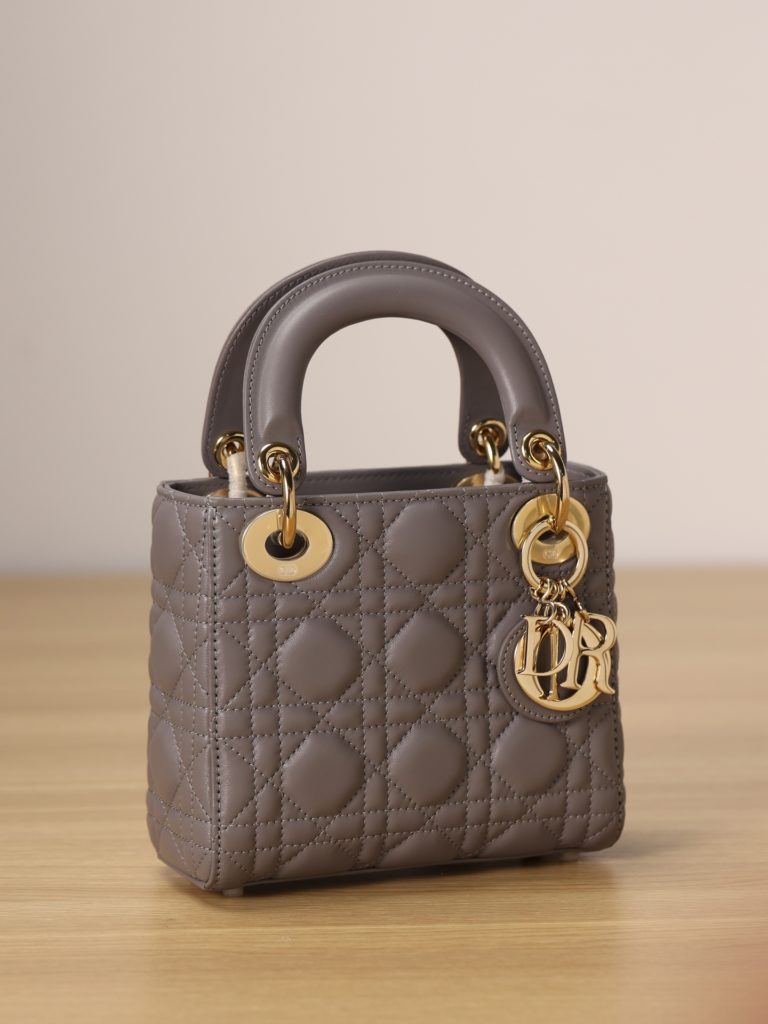 Mini LADY DIOR handbag<br>Elephant grey lamb leather with rattan check<br>Size: 17 x 15 x 7 cm<br>This Lady Dior clutch focuses on Dior's deep insight into elegance and beauty.<br>The chic and elegant design is timeless. Crafted from grey lamb leather, it features eye-catching quilted details in a vine check pattern.<br>A light gold finish metal 