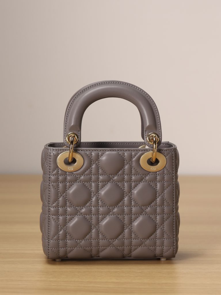 Mini LADY DIOR handbag<br>Elephant grey lamb leather with rattan check<br>Size: 17 x 15 x 7 cm<br>This Lady Dior clutch focuses on Dior's deep insight into elegance and beauty.<br>The chic and elegant design is timeless. Crafted from grey lamb leather, it features eye-catching quilted details in a vine check pattern.<br>A light gold finish metal 