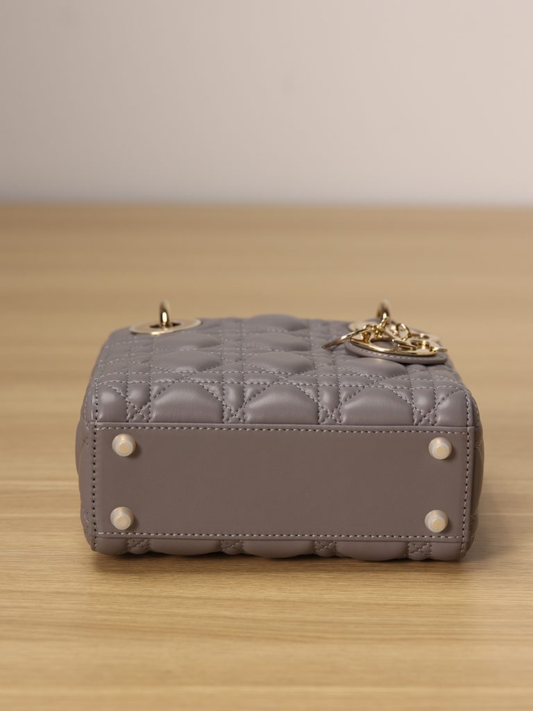 Mini LADY DIOR handbag<br>Elephant grey lamb leather with rattan check<br>Size: 17 x 15 x 7 cm<br>This Lady Dior clutch focuses on Dior's deep insight into elegance and beauty.<br>The chic and elegant design is timeless. Crafted from grey lamb leather, it features eye-catching quilted details in a vine check pattern.<br>A light gold finish metal 