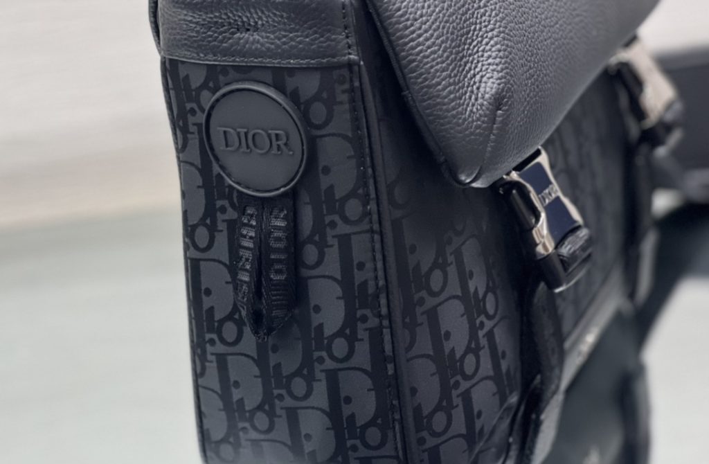 This Dior Explorer messenger bag takes inspiration from a classic design and revitalizes it with a haute couture twist. Crafted from black technical fabric, it is adorned with an Oblique Mirage print and embellished with multiple logos and 