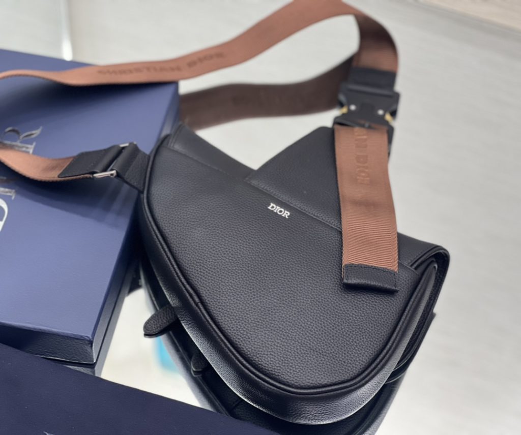 This saddle bag comes from the exclusive co-branded series of Dior and CACTUS JACK. Made of black grain cow leather, embroidered with CACTUS JACK DIOR logo to enhance style. With magnetic flap and hidden zipper closure, it can safely store all kinds of daily necessities. With adjustable 