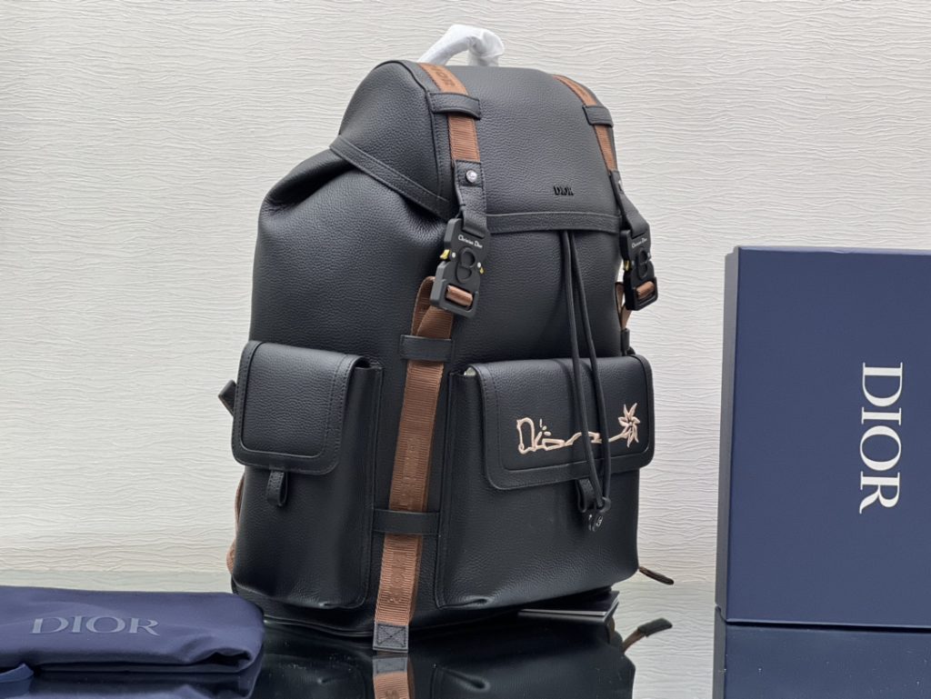 This Dior Hit The Road backpack is a new item of this season, from the exclusive co-branded series of Dior and CACTUS JACK. Made of black grain cow leather, the front is decorated with CACTUS JACK DIOR logo embroidery to enhance style. Pair with two 