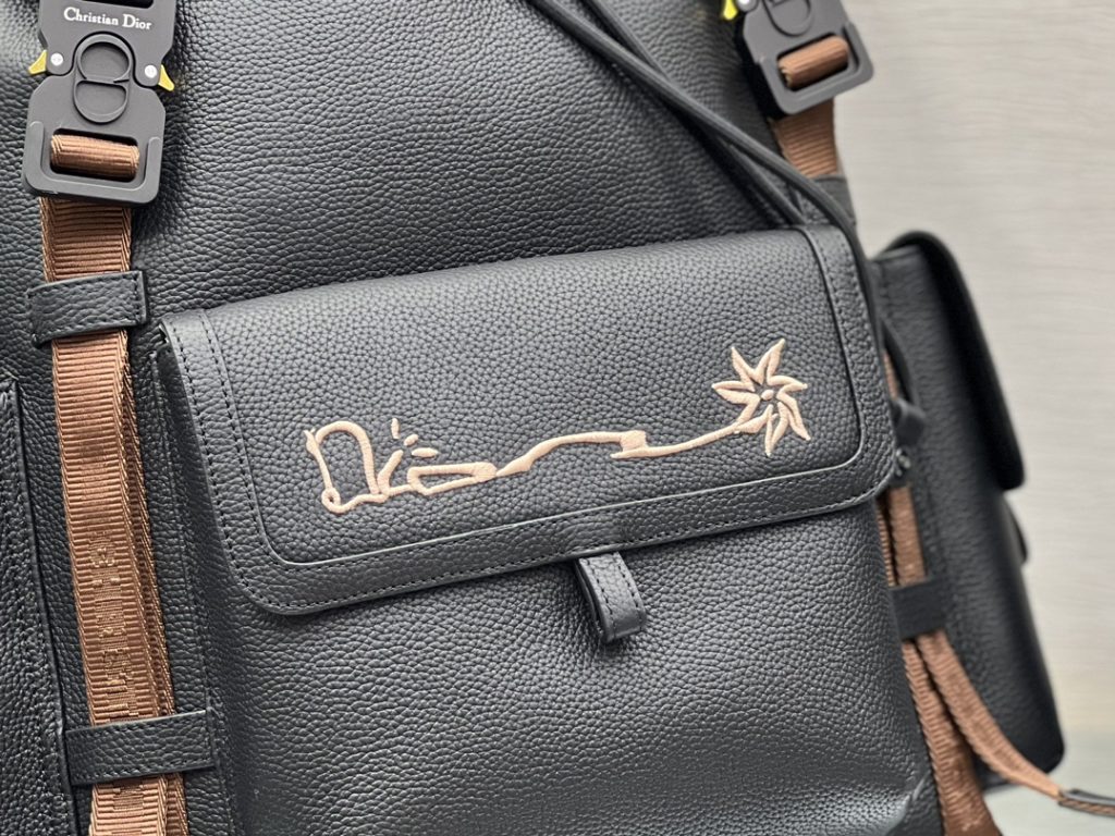 This Dior Hit The Road backpack is a new item of this season, from the exclusive co-branded series of Dior and CACTUS JACK. Made of black grain cow leather, the front is decorated with CACTUS JACK DIOR logo embroidery to enhance style. Pair with two 