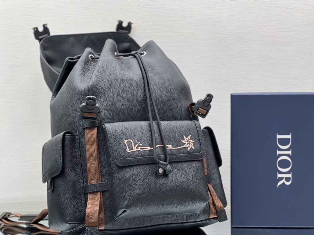 This Dior Hit The Road backpack is a new item of this season, from the exclusive co-branded series of Dior and CACTUS JACK. Made of black grain cow leather, the front is decorated with CACTUS JACK DIOR logo embroidery to enhance style. Pair with two 