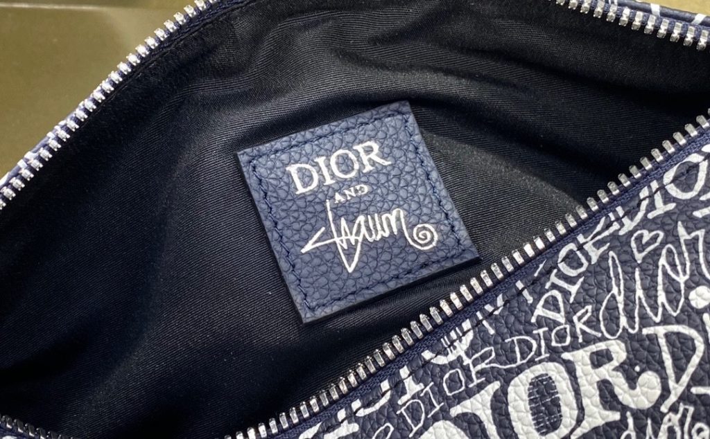 This navy blue Dir AND SHAWN saddle bag is a new series of products created by Dir and designer Shawn Stussy. The classic saddle shape is in sharp contrast with the modern style print. It is elaborately made of grain cow leather, with casual nylon shoulder strap and aluminum buckle, which can add 