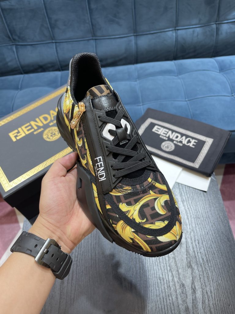 Versace by Fendi pedals sneakers with elastic laces and elastic inserts. The wavy sole is engraved with the word F. Embossed Fendi Flow on the heel. FF nylon with black and gold baroque scarf print. Lycra with FF pattern ® Tongue and Versace Medusa safety pin brooch shaped tab. Lightweight black rubber sole with diagonal F details. Made in Italy Size 39-44 (customized at 38.45)