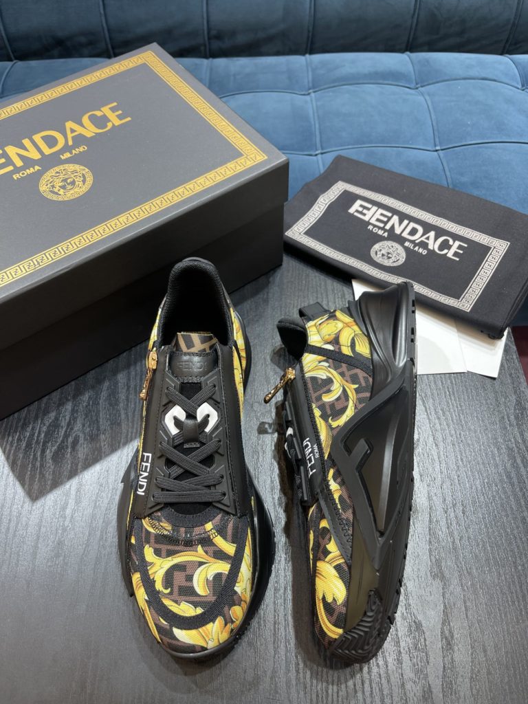 Versace by Fendi pedals sneakers with elastic laces and elastic inserts. The wavy sole is engraved with the word F. Embossed Fendi Flow on the heel. FF nylon with black and gold baroque scarf print. Lycra with FF pattern ® Tongue and Versace Medusa safety pin brooch shaped tab. Lightweight black rubber sole with diagonal F details. Made in Italy Size 39-44 (customized at 38.45)