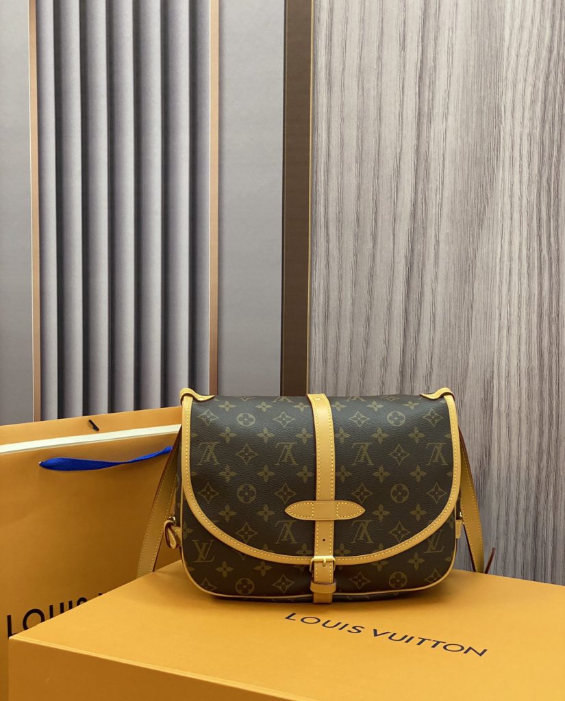 The M40710 Gemini Medieval Series SAUMUR Medium Handbag is made of Monogram canvas. The Saumur Medium Handbag demonstrates the natural elegance of Louis Vuitton. The casual cross body style is more fashionable and appealing, with delicate cowhide trim outlining a very feminine appearance. Size: 28x11x20