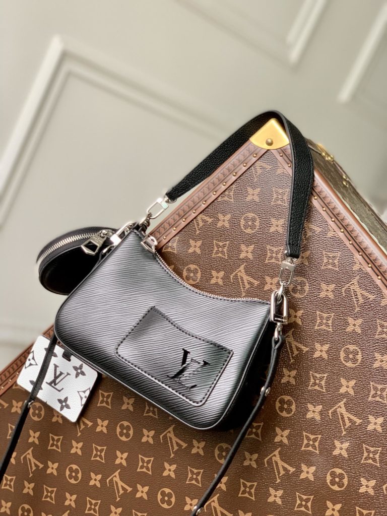 The M20998 Black Marellini handbag features Louis Vuitton's iconic Epi leather, incorporating the flexible elements of the Marelli handbag into a more compact configuration. The round zero wallet can be easily removed and fixed to the mirror of the bag body through a chain to rest in the front patch pocket. 19.0 x 13.5 x 6.5 cm (L x H x W)