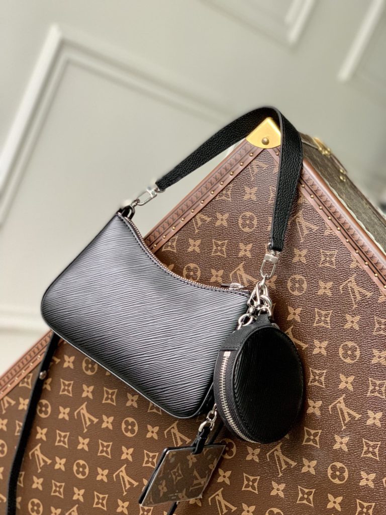 The M20998 Black Marellini handbag features Louis Vuitton's iconic Epi leather, incorporating the flexible elements of the Marelli handbag into a more compact configuration. The round zero wallet can be easily removed and fixed to the mirror of the bag body through a chain to rest in the front patch pocket. 19.0 x 13.5 x 6.5 cm (L x H x W)