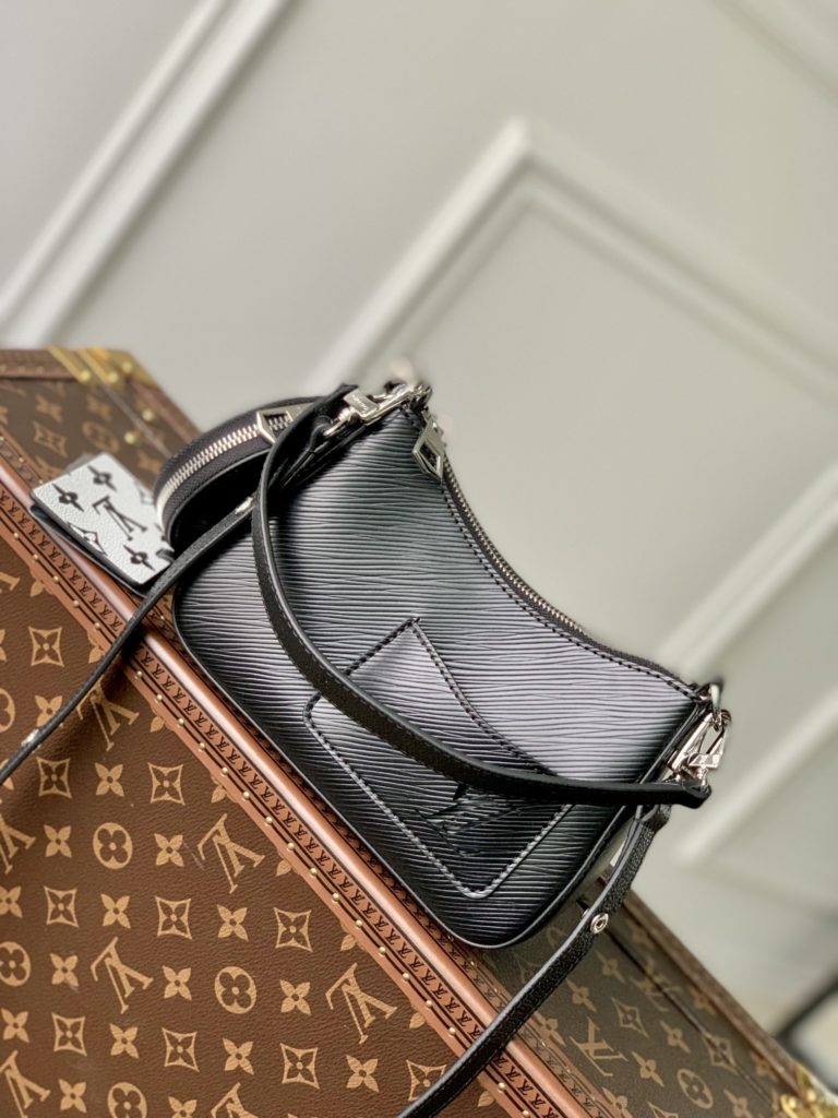 The M20998 Black Marellini handbag features Louis Vuitton's iconic Epi leather, incorporating the flexible elements of the Marelli handbag into a more compact configuration. The round zero wallet can be easily removed and fixed to the mirror of the bag body through a chain to rest in the front patch pocket. 19.0 x 13.5 x 6.5 cm (L x H x W)