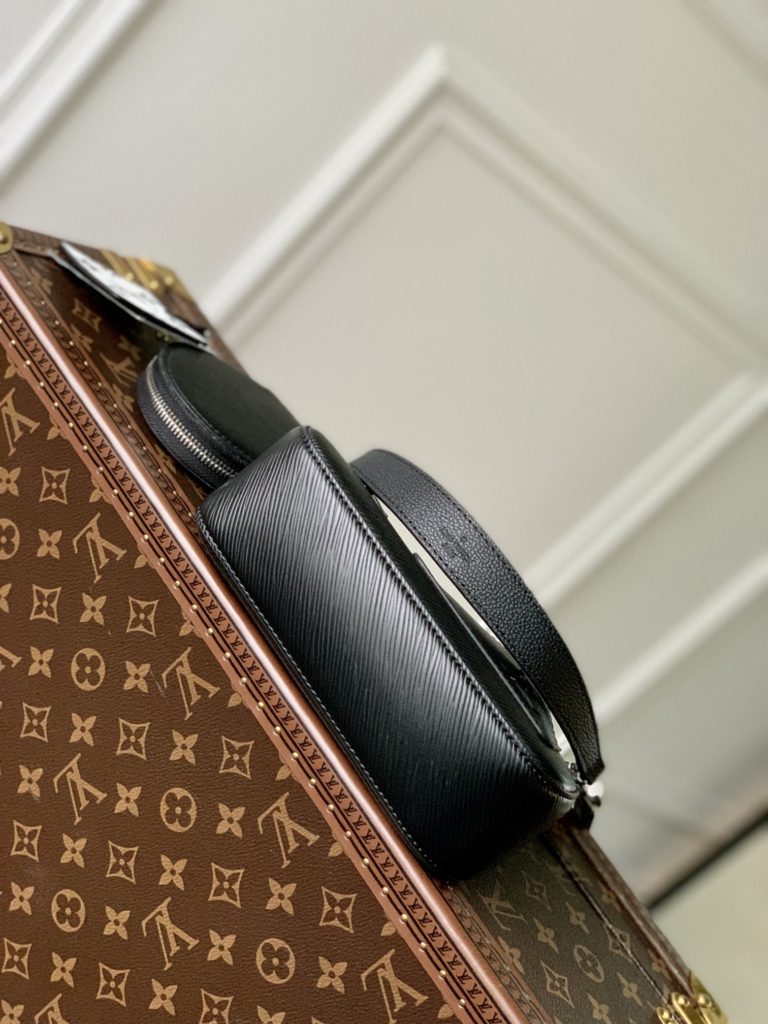 The M20998 Black Marellini handbag features Louis Vuitton's iconic Epi leather, incorporating the flexible elements of the Marelli handbag into a more compact configuration. The round zero wallet can be easily removed and fixed to the mirror of the bag body through a chain to rest in the front patch pocket. 19.0 x 13.5 x 6.5 cm (L x H x W)