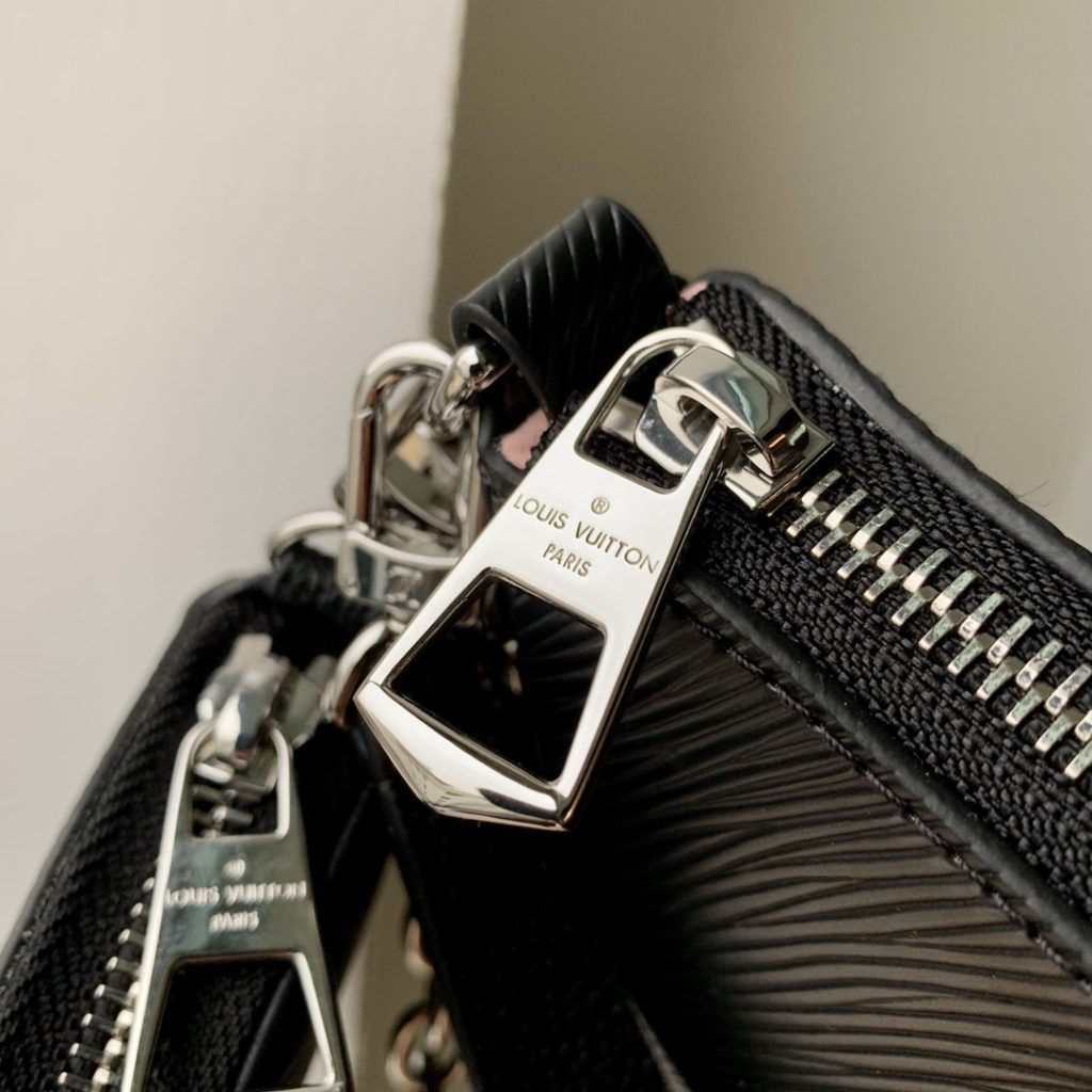 The M20998 Black Marellini handbag features Louis Vuitton's iconic Epi leather, incorporating the flexible elements of the Marelli handbag into a more compact configuration. The round zero wallet can be easily removed and fixed to the mirror of the bag body through a chain to rest in the front patch pocket. 19.0 x 13.5 x 6.5 cm (L x H x W)