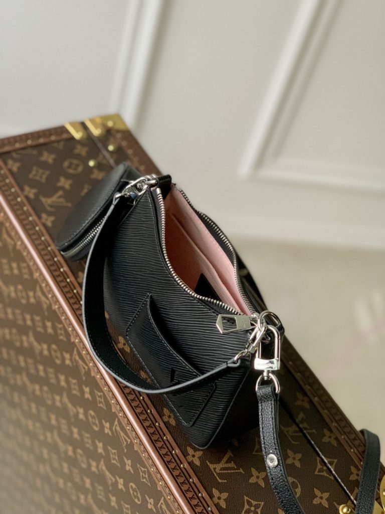 The M20998 Black Marellini handbag features Louis Vuitton's iconic Epi leather, incorporating the flexible elements of the Marelli handbag into a more compact configuration. The round zero wallet can be easily removed and fixed to the mirror of the bag body through a chain to rest in the front patch pocket. 19.0 x 13.5 x 6.5 cm (L x H x W)