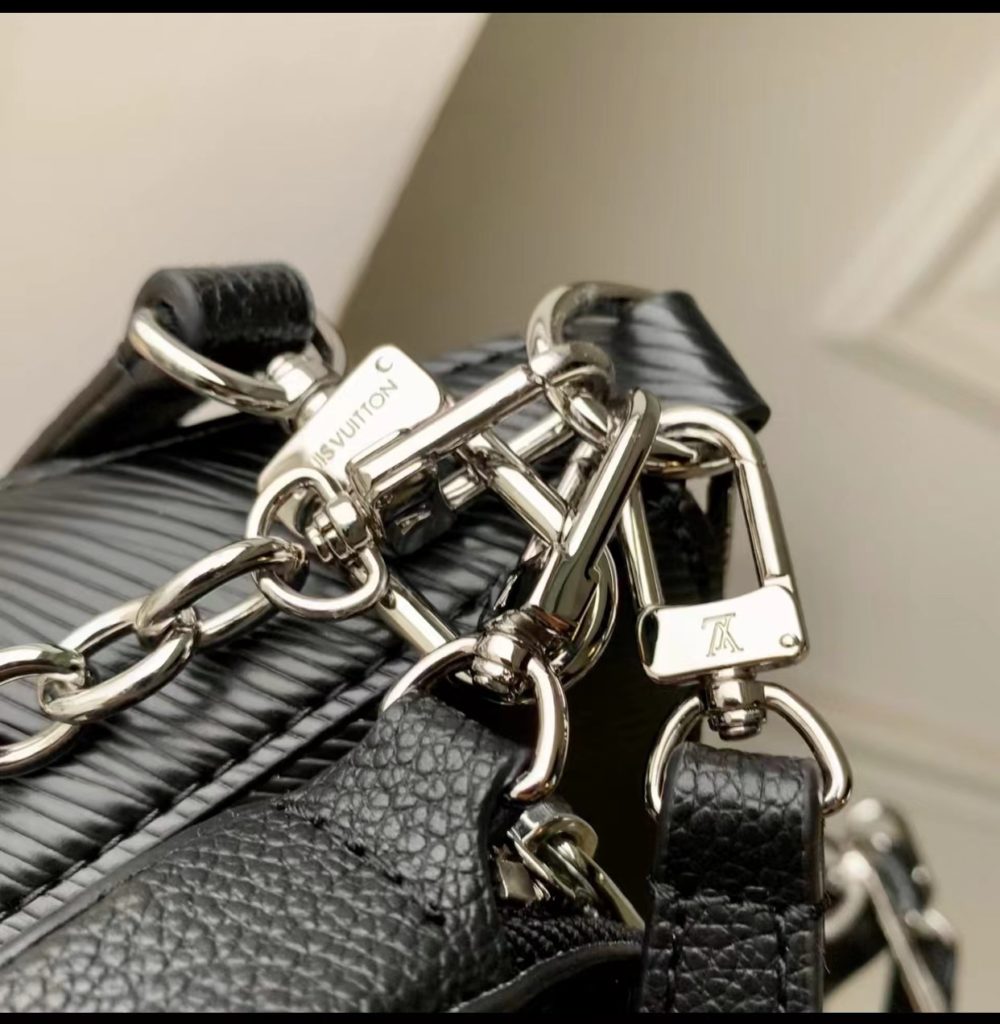 The M20998 Black Marellini handbag features Louis Vuitton's iconic Epi leather, incorporating the flexible elements of the Marelli handbag into a more compact configuration. The round zero wallet can be easily removed and fixed to the mirror of the bag body through a chain to rest in the front patch pocket. 19.0 x 13.5 x 6.5 cm (L x H x W)