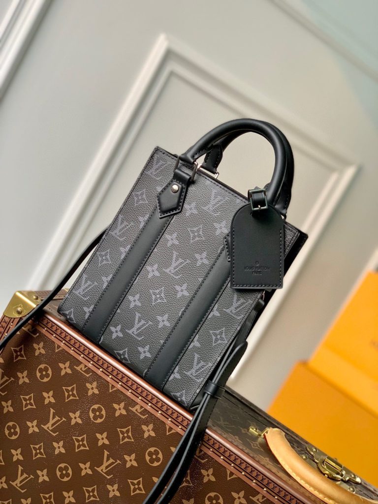 The Black Embossed Vertical Trunk Mini Handbag demonstrates Louis Vuitton's box making heritage and modern concept. Taurilon leather is embossed with a classic Monogram graphic, a magnetic snap flap for secure storage, and a detachable and adjustable shoulder strap facilitates shoulder and back. size：10.7x17.5x6.8cm