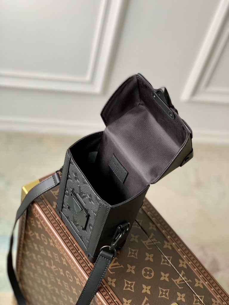 The Black Embossed Vertical Trunk Mini Handbag demonstrates Louis Vuitton's box making heritage and modern concept. Taurilon leather is embossed with a classic Monogram graphic, a magnetic snap flap for secure storage, and a detachable and adjustable shoulder strap facilitates shoulder and back. size：10.7x17.5x6.8cm