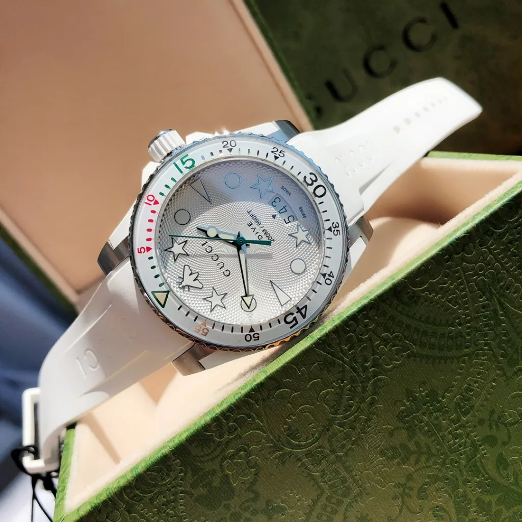 The new Gucci unisex diving watch in stock, 40 mm diameter, features the brand's signature luminous display as the dial. In stainless steel with satin-brushed finishing, it is fitted with a rubber strap in the same colour as the dial. The unidirectional rotating bezel of the dial is also decorated with luminescent hour markers for diving countdowns and is water resistant to 200 metres.