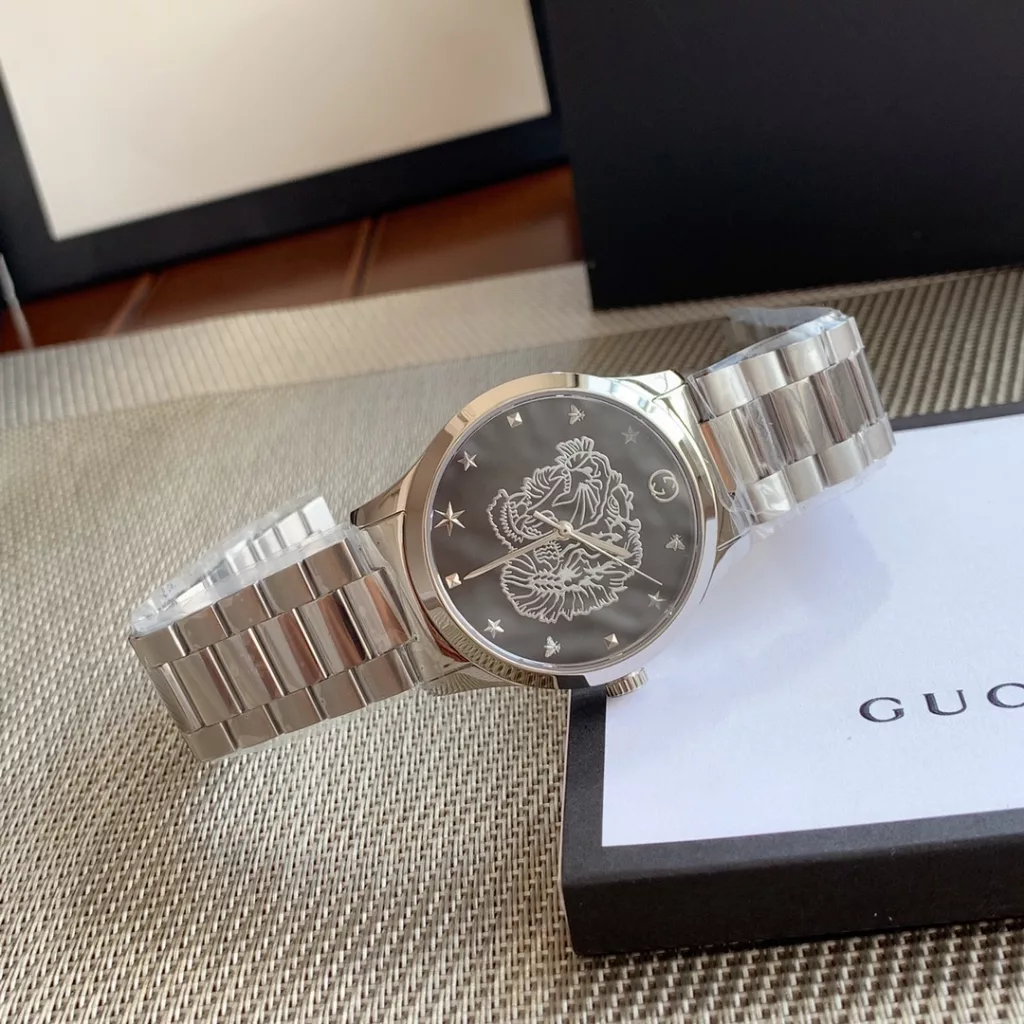 gucci Gucci G I Timeless watch, unisex quartz, 38mm, sapphire crystal, stainless steel case and strap, decorated with a silver tiger head motif, water-resistant to 50m, original box plus 30!