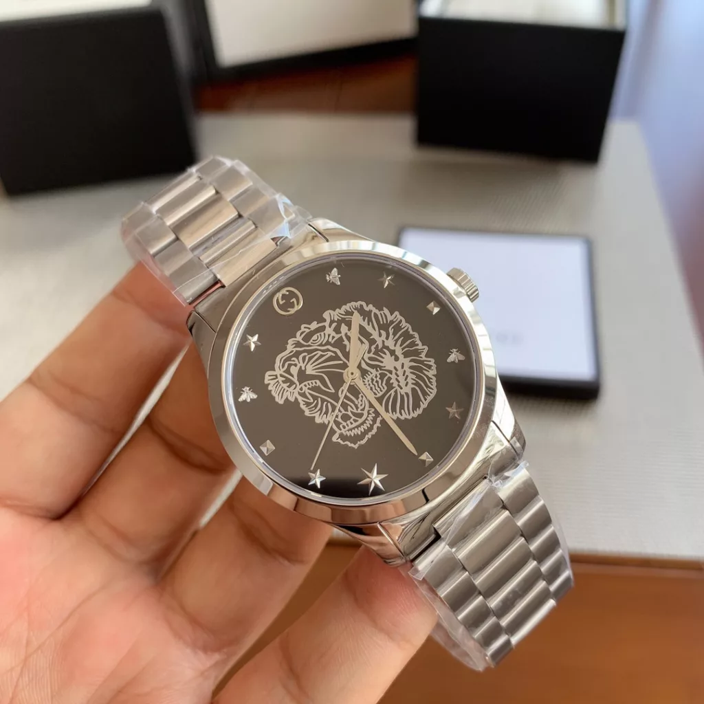 gucci Gucci G I Timeless watch, unisex quartz, 38mm, sapphire crystal, stainless steel case and strap, decorated with a silver tiger head motif, water-resistant to 50m, original box plus 30!