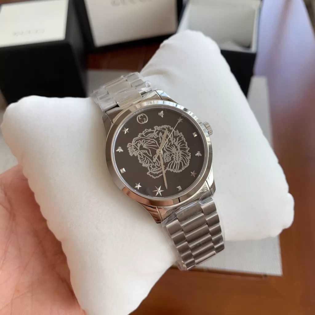 gucci Gucci G I Timeless watch, unisex quartz, 38mm, sapphire crystal, stainless steel case and strap, decorated with a silver tiger head motif, water-resistant to 50m, original box plus 30!