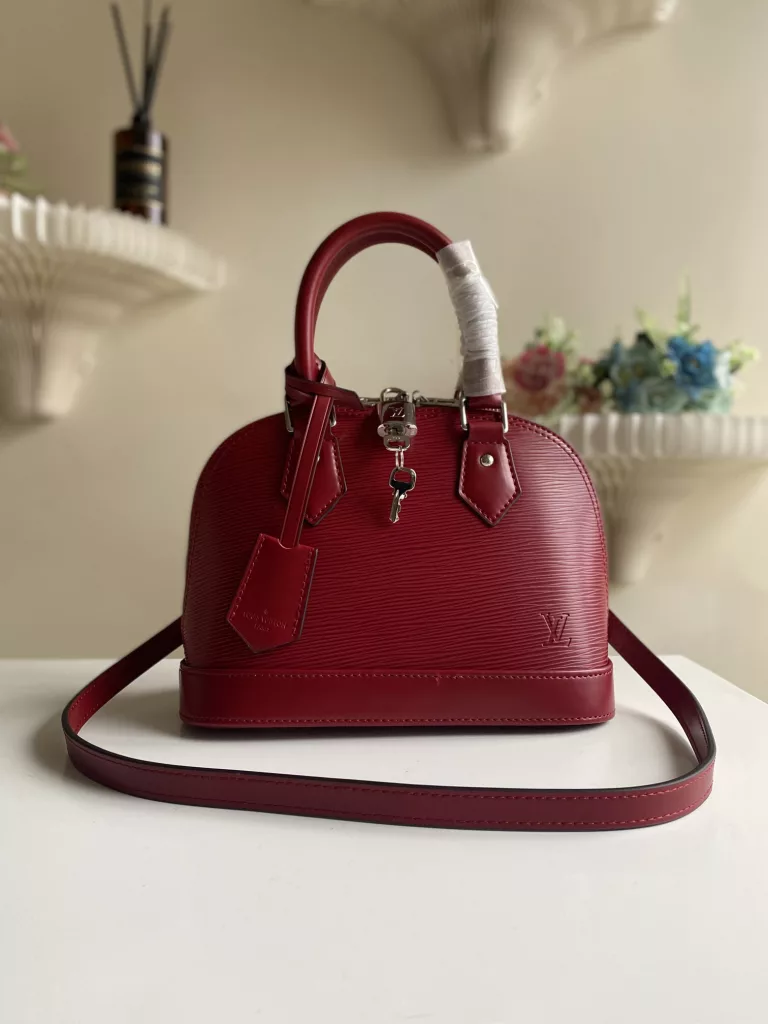 The top-level original ALMA BB handbag M40301 Carmine Red This Alma BB handbag M40302 M80862 presents a classic configuration in Epi grain leather, incorporating iconic elements such as a padlock, hand sewn Toron handle, and keycase. Removable shoulder straps for shoulder to shoulder or crossbody. Size: 23.5 * 17.5 * 11.5 cm