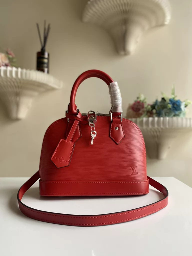 The top-level original ALMA BB handbag M40301 Carmine Red This Alma BB handbag M40302 M80862 presents a classic configuration in Epi grain leather, incorporating iconic elements such as a padlock, hand sewn Toron handle, and keycase. Removable shoulder straps for shoulder to shoulder or crossbody. Size: 23.5 * 17.5 * 11.5 cm