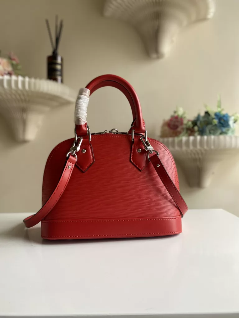 The top-level original ALMA BB handbag M40301 Carmine Red This Alma BB handbag M40302 M80862 presents a classic configuration in Epi grain leather, incorporating iconic elements such as a padlock, hand sewn Toron handle, and keycase. Removable shoulder straps for shoulder to shoulder or crossbody. Size: 23.5 * 17.5 * 11.5 cm