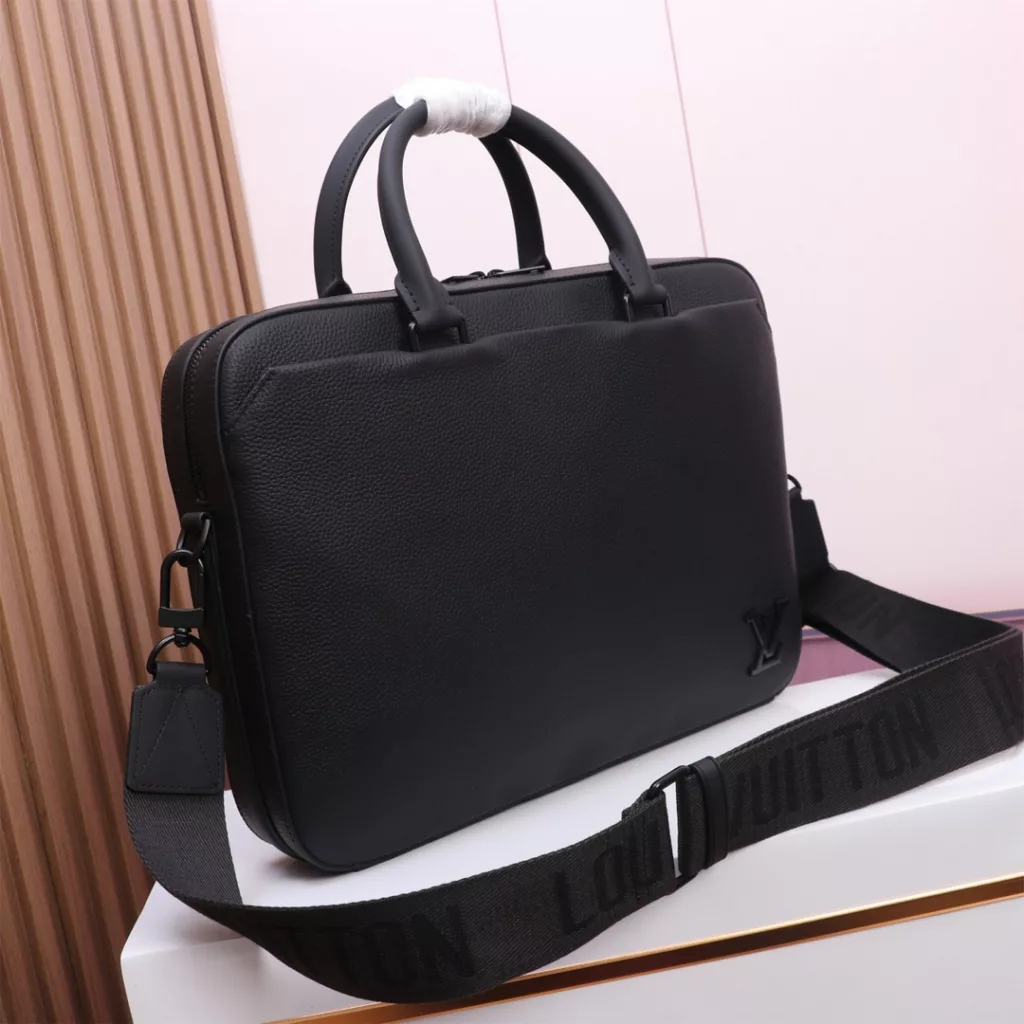 【PILOT Briefcase 】M23778 BlackThis Pilot leather briefcase combines modern design with practical functions. The inner bag and the compartment are equipped with a magnetic buckle to open and close, which is convenient for taking and placing personal objects. The front pocket has a beveled Angle design and the same color LV letters show the LV Aerogram series style.   Dimensions: 39 x 29 x 6 cm