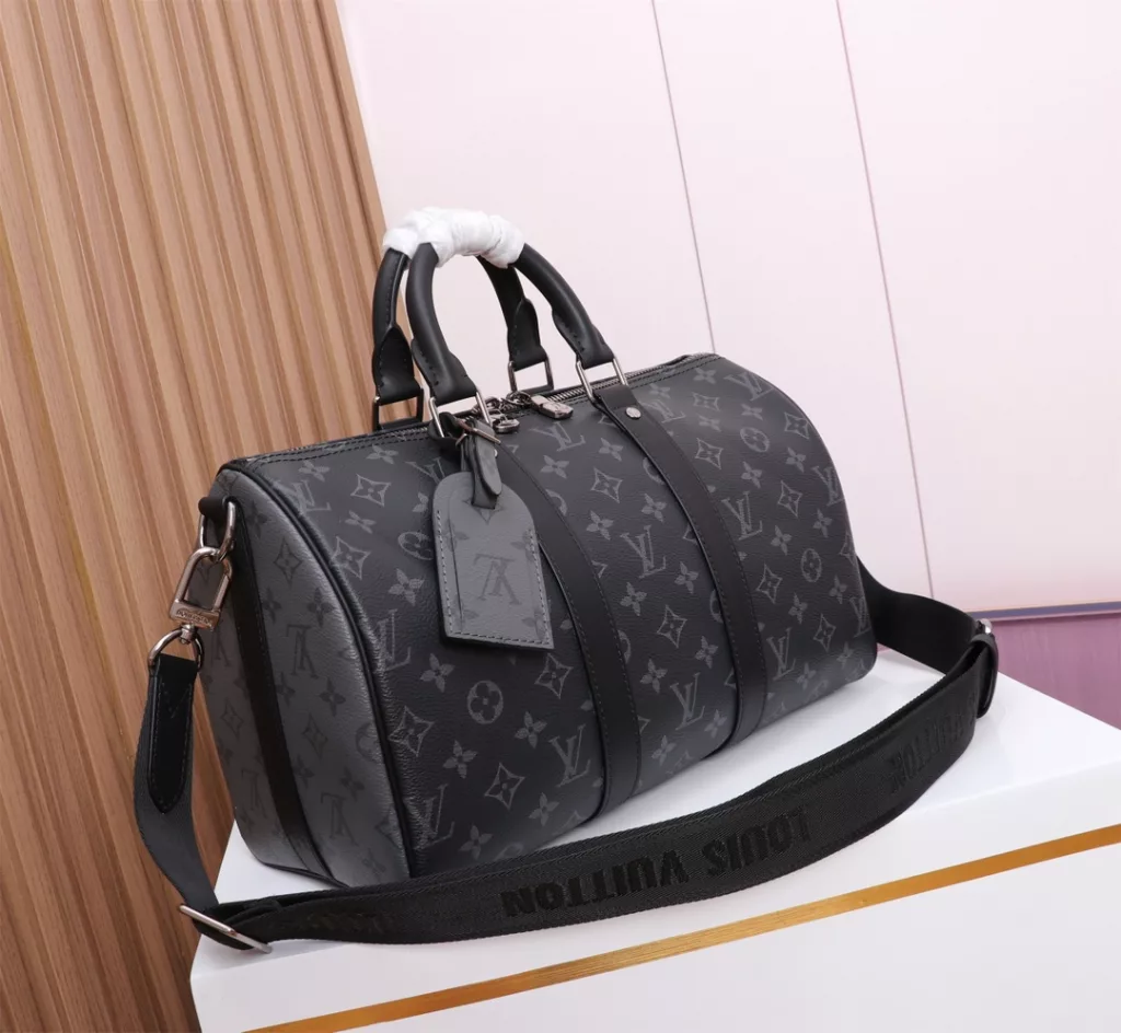 Keepall 35 Handbag M46655 Black flowerKeepall 35 travel bag, tailored from the new signature Monogram Eclipse canvas. Since 1930, the Keepall series of bags have accompanied generations of travelers around the world. This new travel bag comes with multiple leather handles for comfortable holding, a strap for a leisurely crossbody and a shiny padlock for short trips. The side strap and top rolled leather handles follow the classic Keepall travel bag design, and the detachable and adjustable fabric shoulder strap is convenient for shoulder or crossbody, with a slight increase in capacity compared to the City Keepall bag.  Size: 35x21x6cm