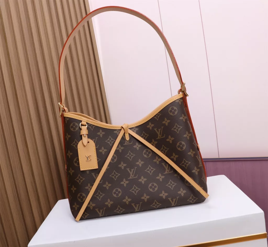 The M46203 CarryAll small bag features Monogram canvas and leather trim. The ample configuration features a neat lining, while the large inner bag adds functional elements. The Monogram canvas zipper clutch bag is secured with a leather strap. Dimensions: 29.0 x 24.0 x 12.0 cm