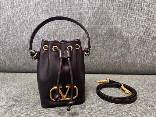 VALENTINO GARAVANIVLOGO SIGNATURE soft lambskin mini bucket bag. Thanks to the detachable shoulder strap and handle design, this mini handbag can be carried on the shoulder, crossbody or by hand at will.