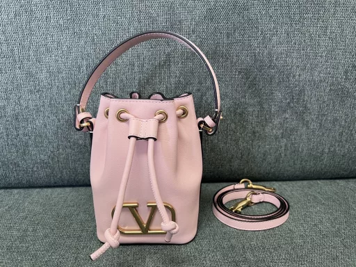 VALENTINO GARAVANIVLOGO SIGNATURE soft lambskin mini bucket bag. Thanks to the detachable shoulder strap and handle design, this mini handbag can be carried on the shoulder, crossbody or by hand at will.