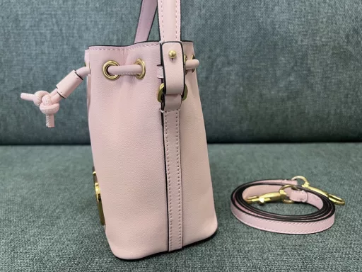 VALENTINO GARAVANIVLOGO SIGNATURE soft lambskin mini bucket bag. Thanks to the detachable shoulder strap and handle design, this mini handbag can be carried on the shoulder, crossbody or by hand at will.