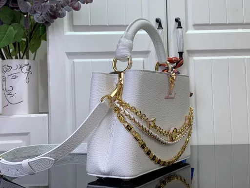 This Capucines BB bag from the Trilogy collection is elegantly crafted with Taurillon leather and striking hardware. The gorgeous chain is embellished with a mini padlock and enamel Monogram flowers, and the flap can be opened externally or internally to open multiple pockets. The sophisticated design allows for a variety of carrying options.