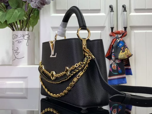 This Capucines BB bag from the Trilogy collection is elegantly crafted with Taurillon leather and striking hardware. The gorgeous chain is embellished with a mini padlock and enamel Monogram flowers, and the flap can be opened externally or internally to open multiple pockets. The sophisticated design allows for a variety of carrying options.