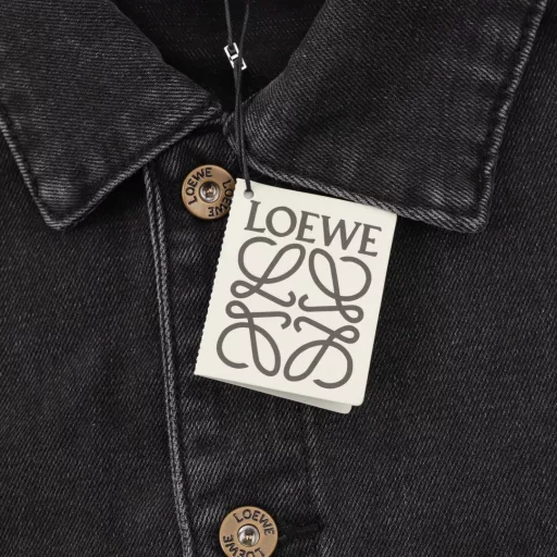 LOEWE Denim Embroidered JacketUsing tight double-core yarn, laser-cut Anagram on the knees, classic LOEWE leather label, laser-cut, manually unpacked, laid flat to make laser-cut Anagram pattern, then manually patched inside and finally manually sewn on, expensive labor, high loss, low daily output, imported special machine infrared positioning, washing and color frying process, priority is given to special desizing agent, then the fabric is soaked in it to be evenly sizing before rinsing, loose version